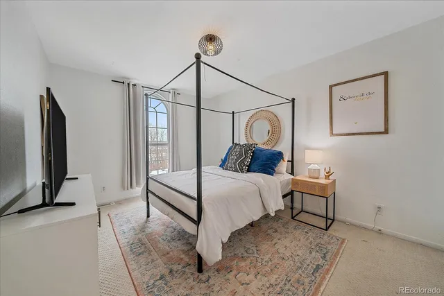 a bedroom with a bed mirror and window