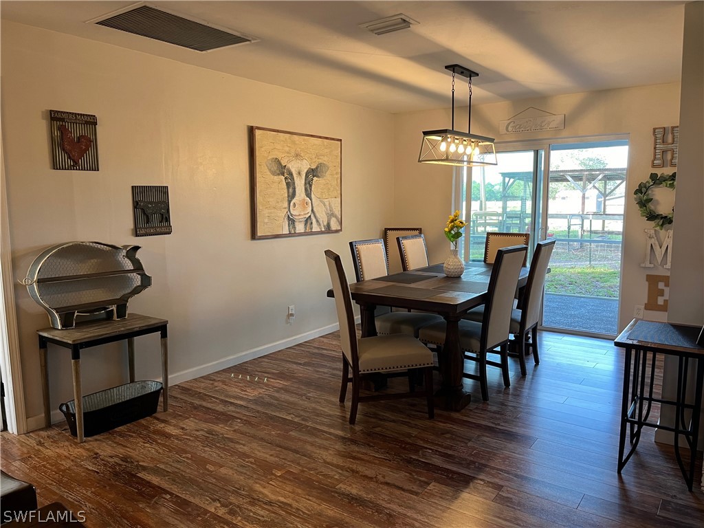 13100 Rod And Gun Club Road Fort Myers, FL 33913 - Photo 13 of 37 a dining room with furniture and wooden floor