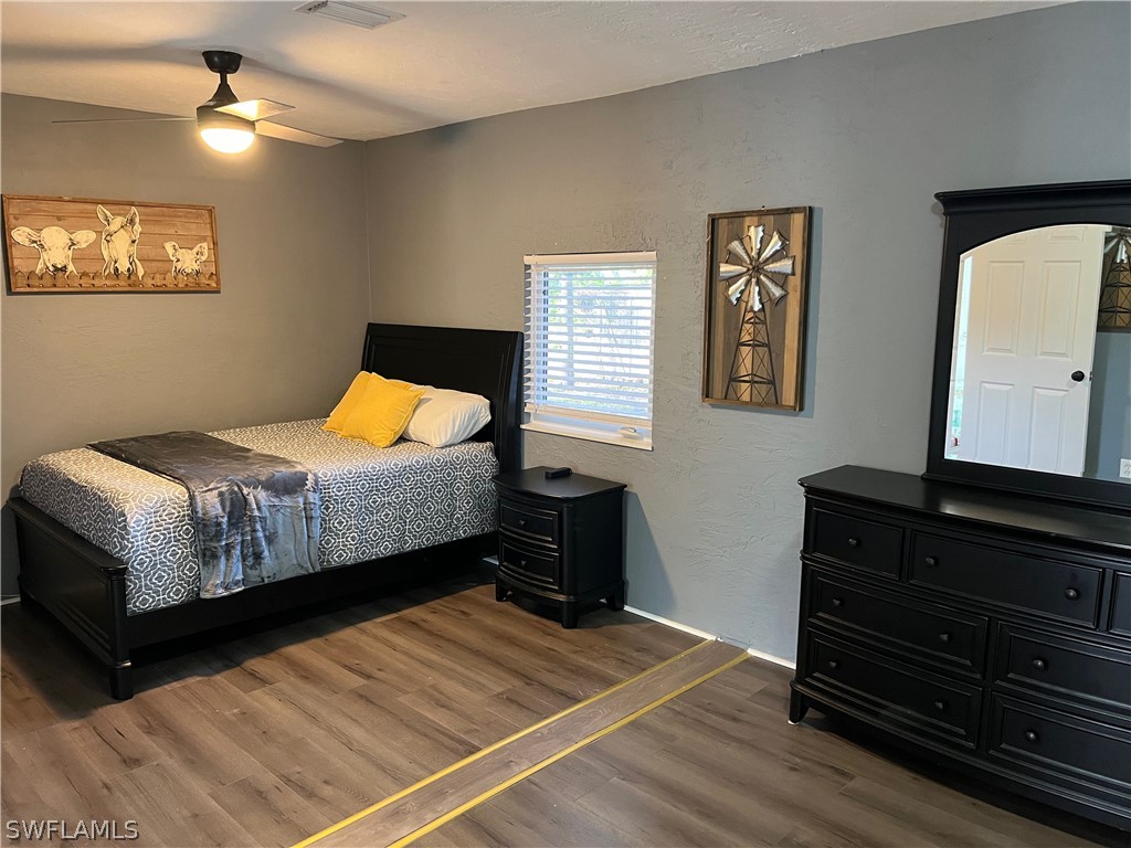 13100 Rod And Gun Club Road Fort Myers, FL 33913 - Photo 21 of 37 a bedroom with a bed and wooden floor