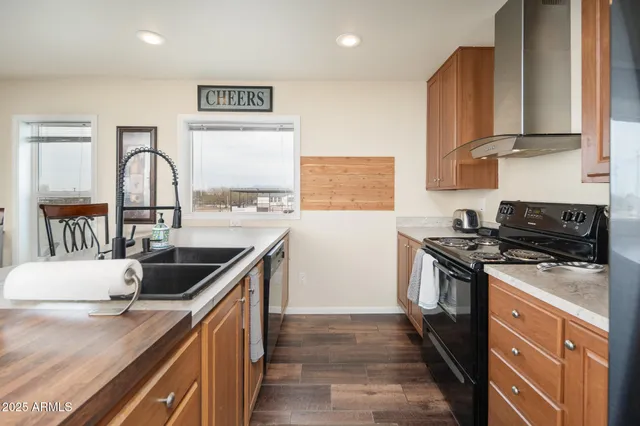 a kitchen with stainless steel appliances granite countertop a refrigerator a stove a sink dishwasher and a refrigerator with wooden floor