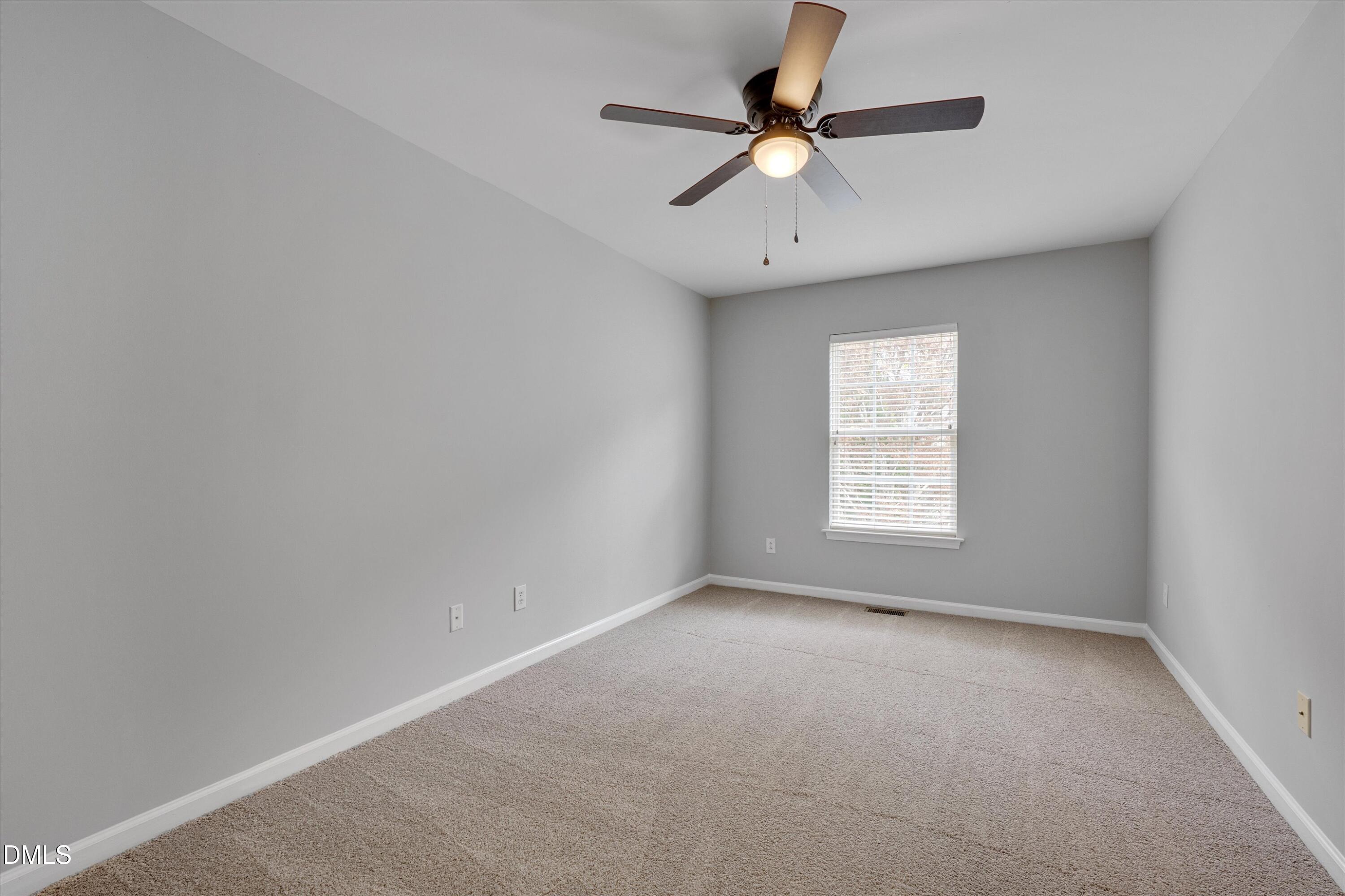 2621 Ivory Run Way, Unit 105 Raleigh, NC 27603 - Photo 13 of 21 an empty room with a window and a fan