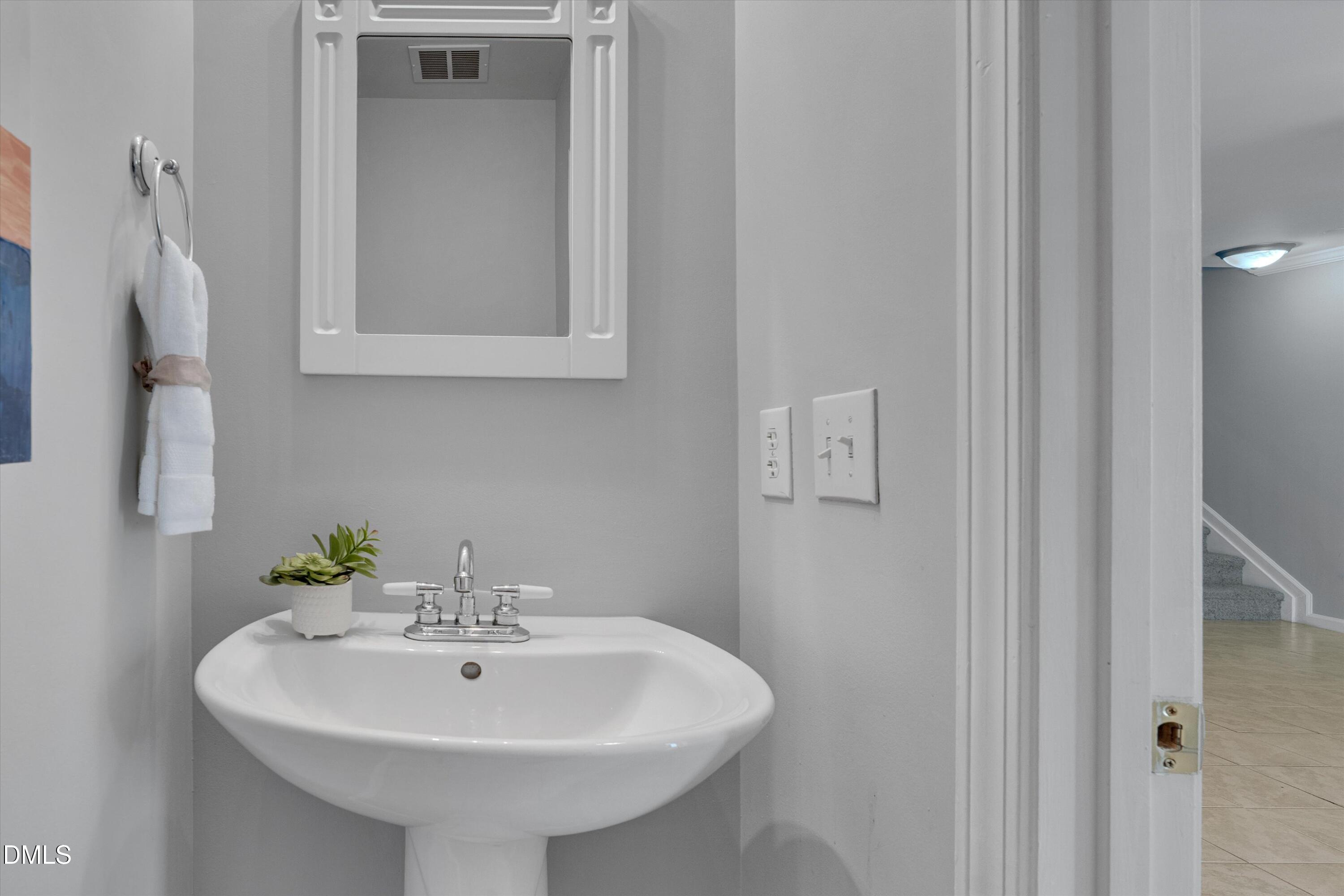 2621 Ivory Run Way, Unit 105 Raleigh, NC 27603 - Photo 7 of 21 a bathroom with a sink and a mirror