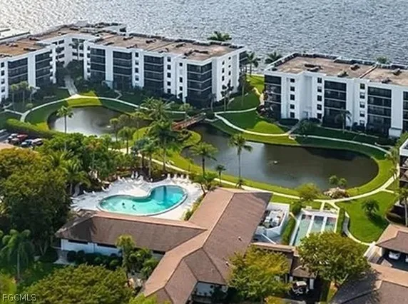 an aerial view of a house with swimming pool and large trees