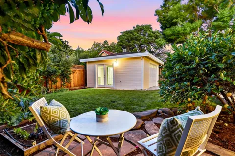 a backyard of a house with table and chairs