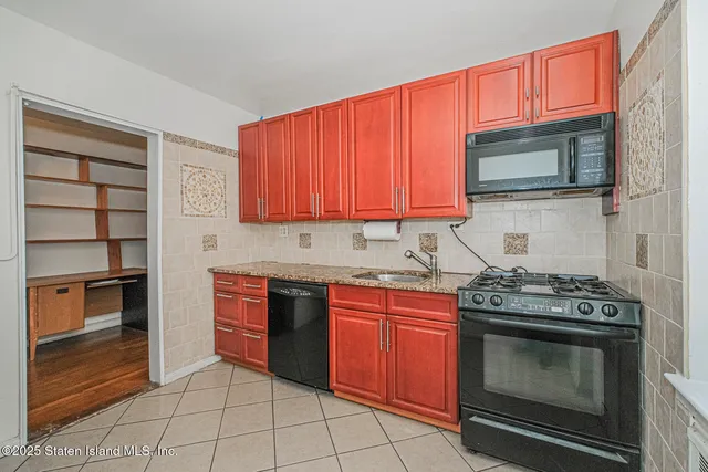 a kitchen with stainless steel appliances granite countertop a stove top oven microwave and cabinets