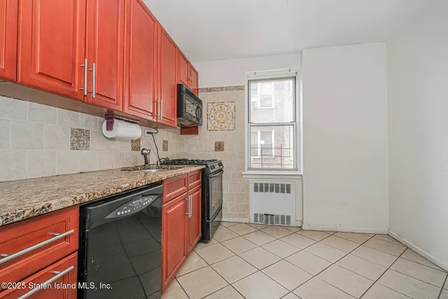 a kitchen with stainless steel appliances granite countertop a sink and a white cabinets