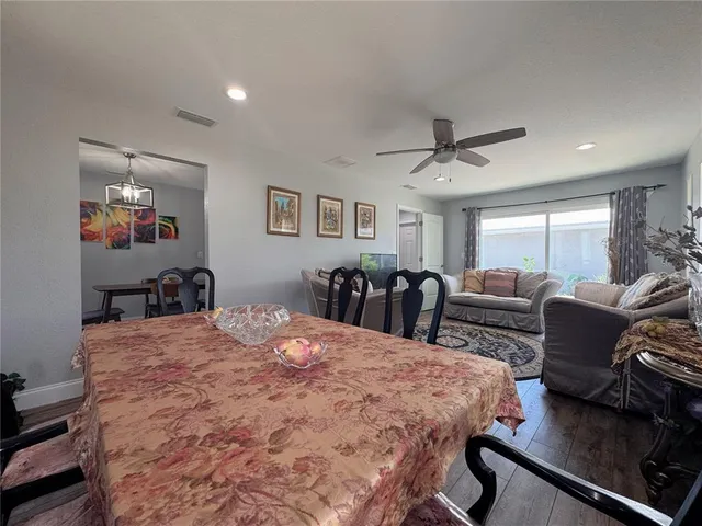 a kitchen with stainless steel appliances a microwave a stove a sink dishwasher and white cabinets with wooden floor