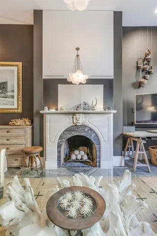 a living room with furniture a fireplace and a chandelier