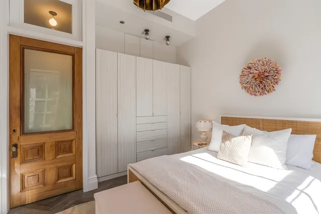 a spacious bedroom with a bed a table and chair