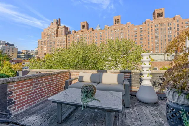 a view of a chair and table in the back yard of the house
