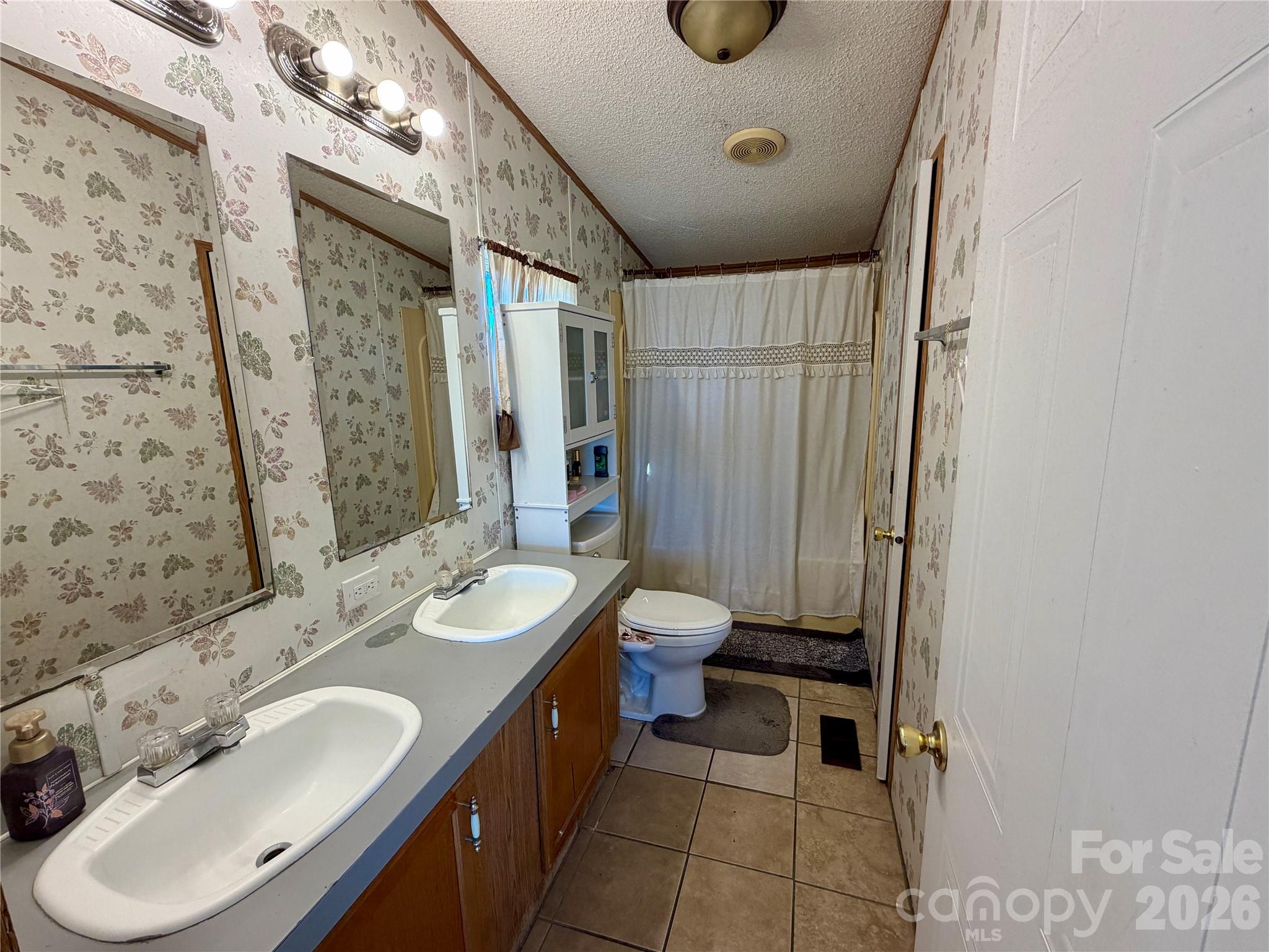 2390 Claremont Road Newton, NC 28658 - Photo 8 of 11 a bathroom with a double vanity sink toilet and shower