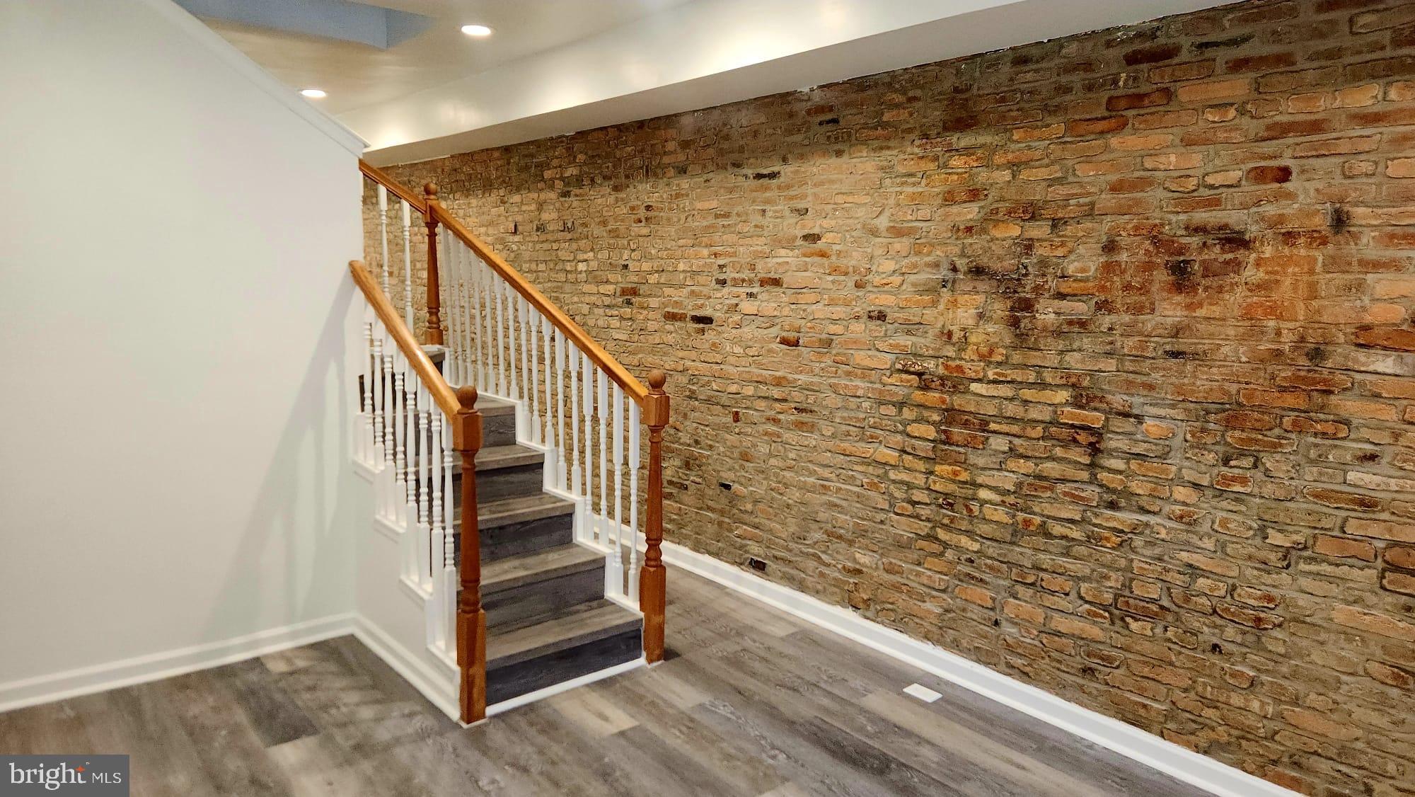 Charming staircase with exposed brick wall.