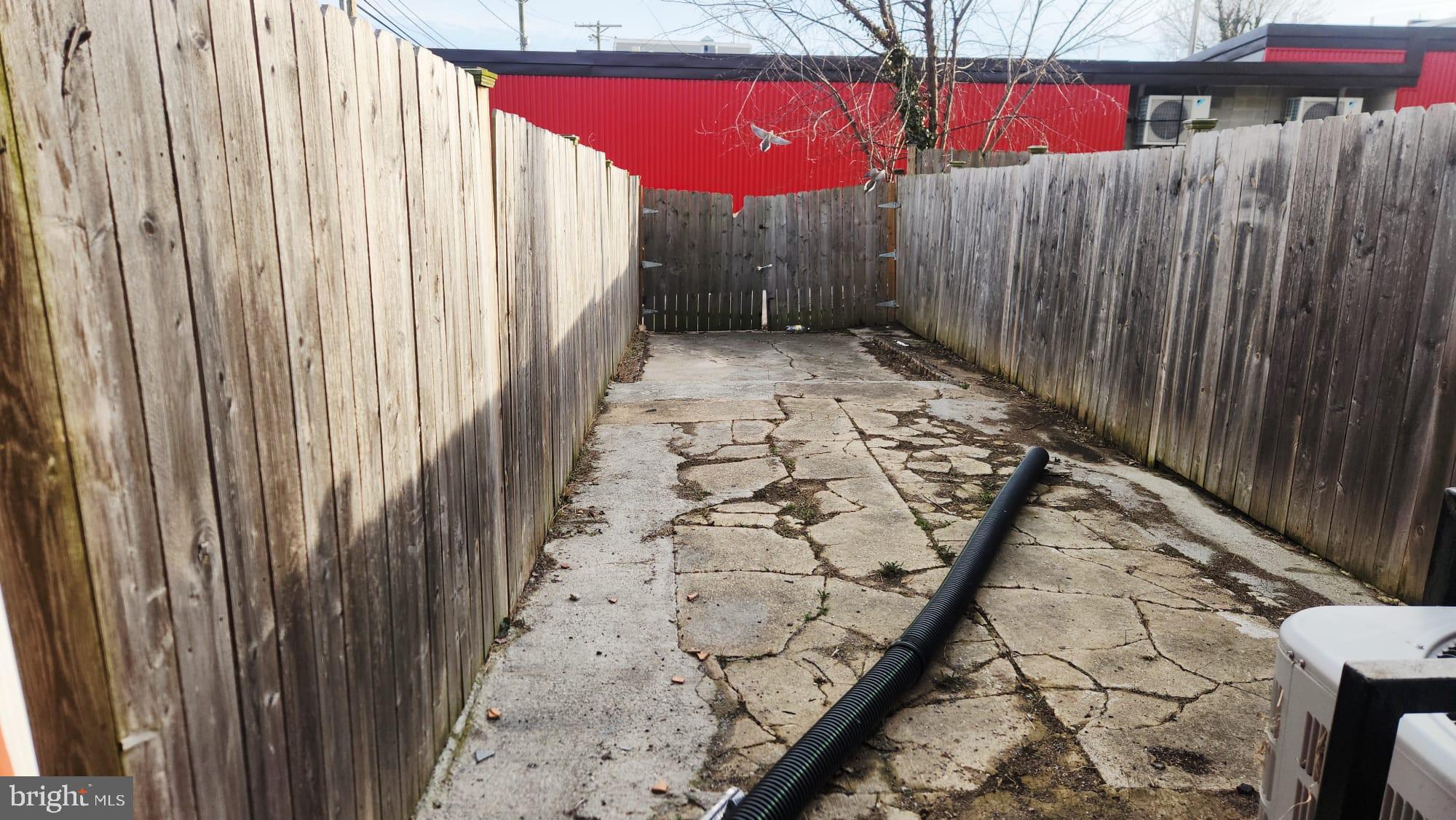 519 East 28th Street Baltimore, MD 21218 - Photo 22 of 46 Narrow outdoor space with weathered fencing.