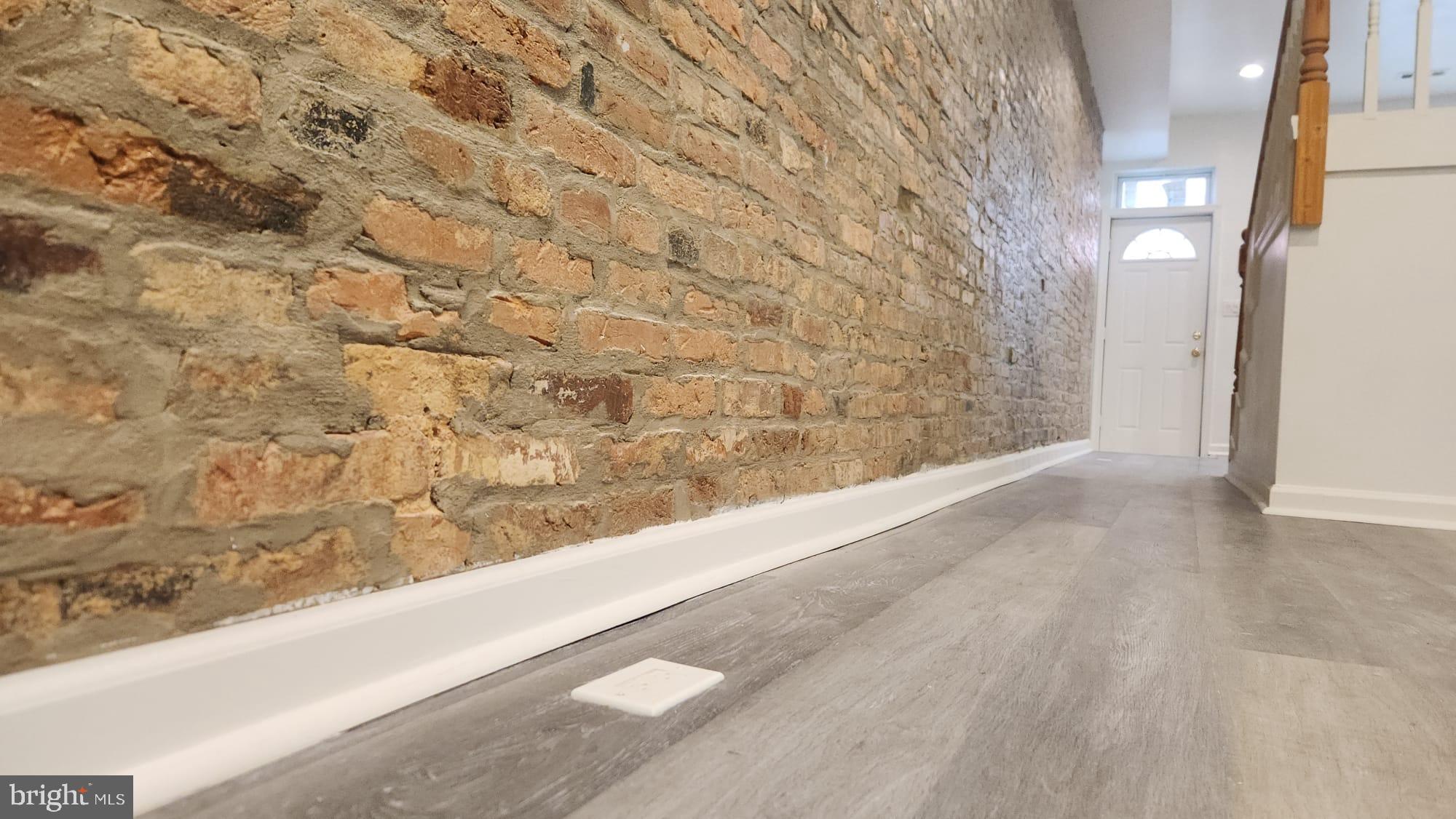 519 East 28th Street Baltimore, MD 21218 - Photo 3 of 46 Charming hallway with exposed brick wall.
