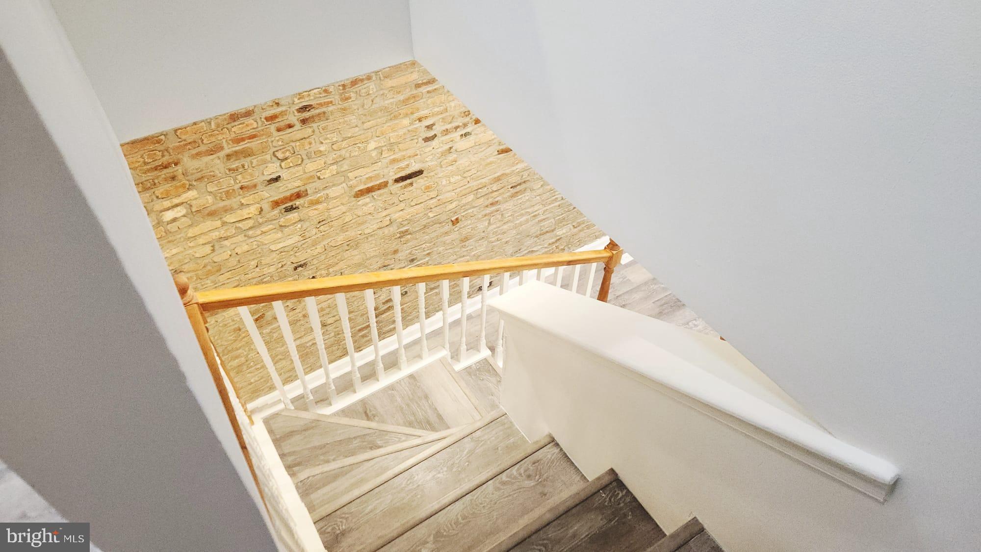 519 East 28th Street Baltimore, MD 21218 - Photo 43 of 46 Charming staircase with rustic brick wall.