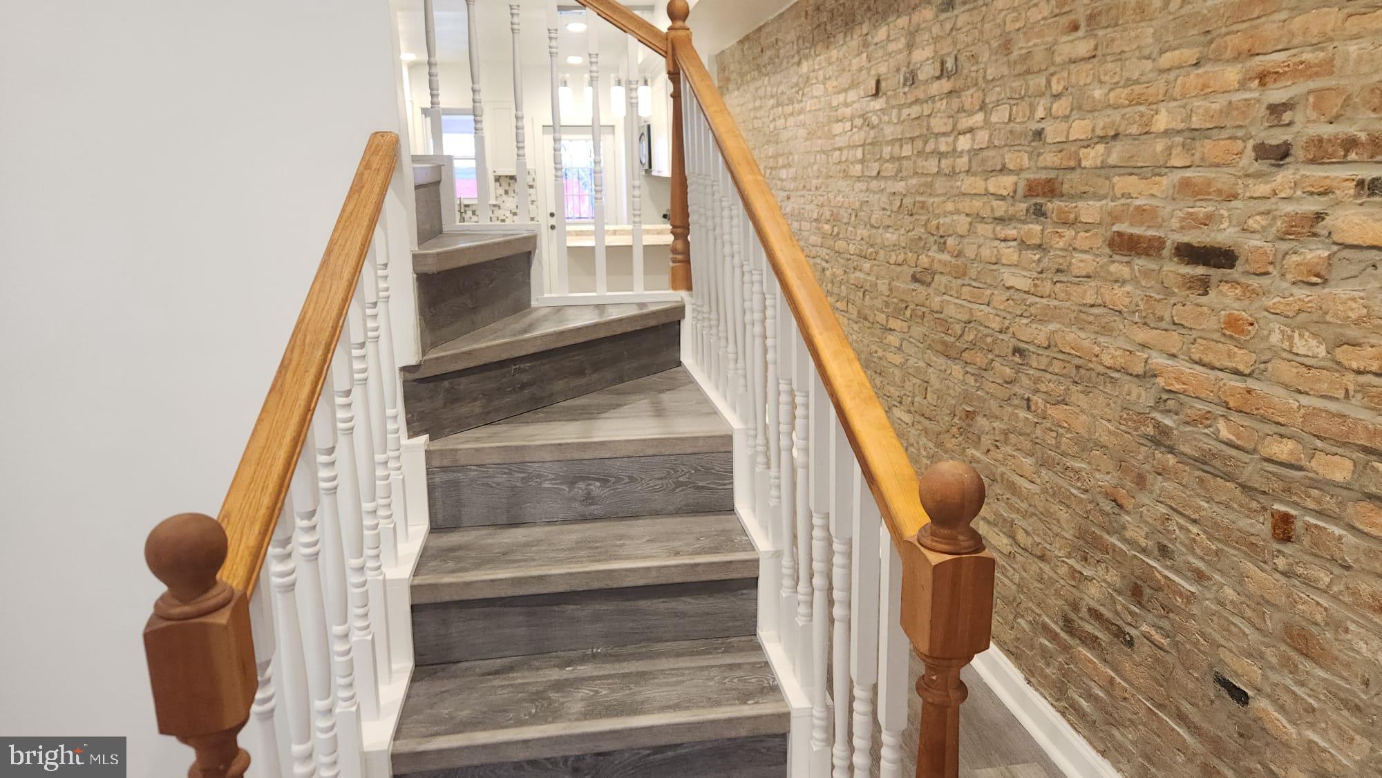 519 East 28th Street Baltimore, MD 21218 - Photo 44 of 46 Elegant staircase with rustic brick wall.