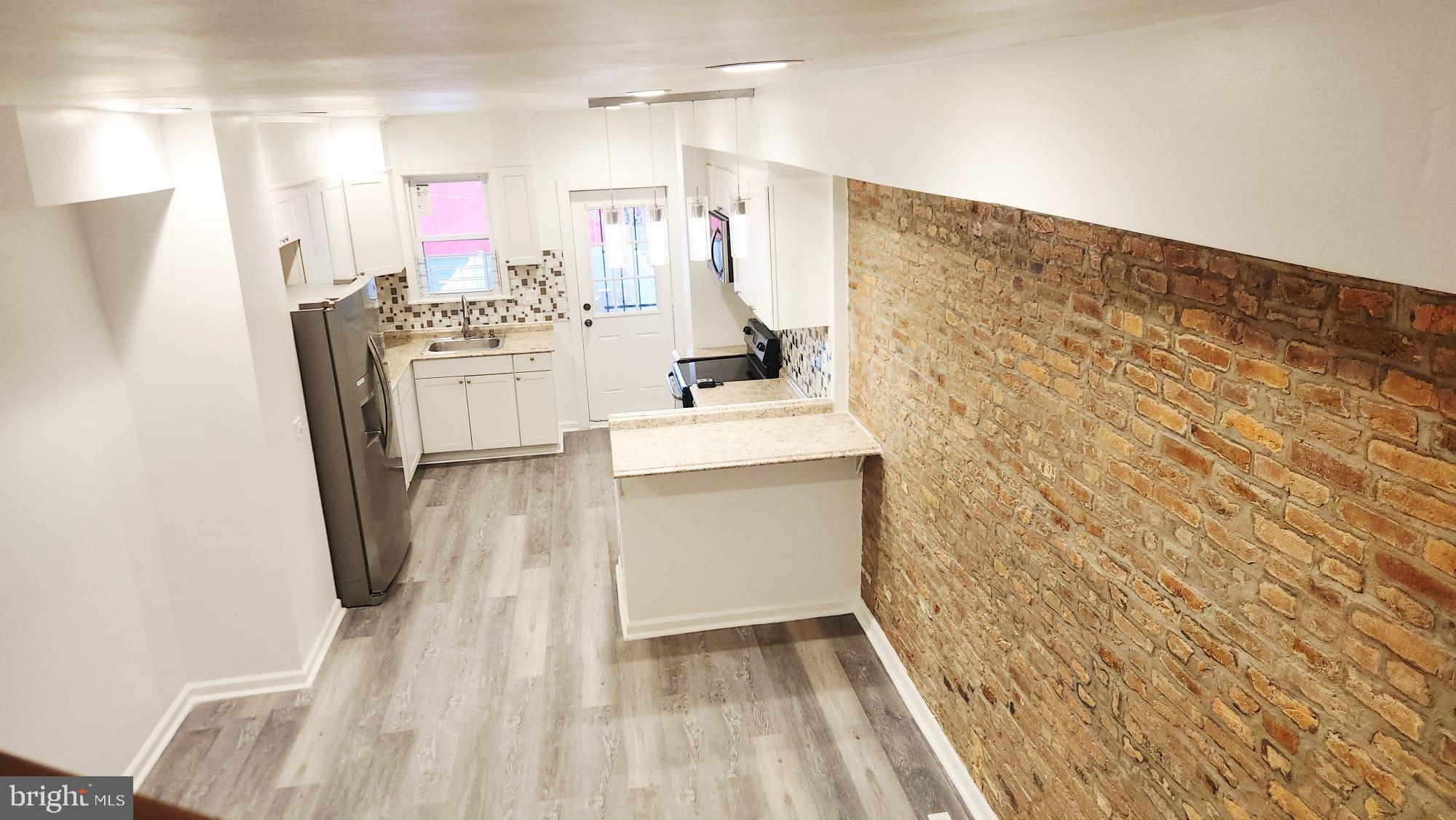 519 East 28th Street Baltimore, MD 21218 - Photo 5 of 46 Charming open space with rustic brick accents.