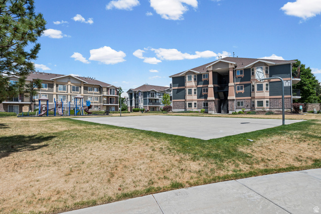 8248 South Resaca Drive, Unit J10 Sandy, UT 84070 - Photo 34 of 40 Basketball court with a playground, surrounded by multi-story residential buildings featuring brick and siding exteriors