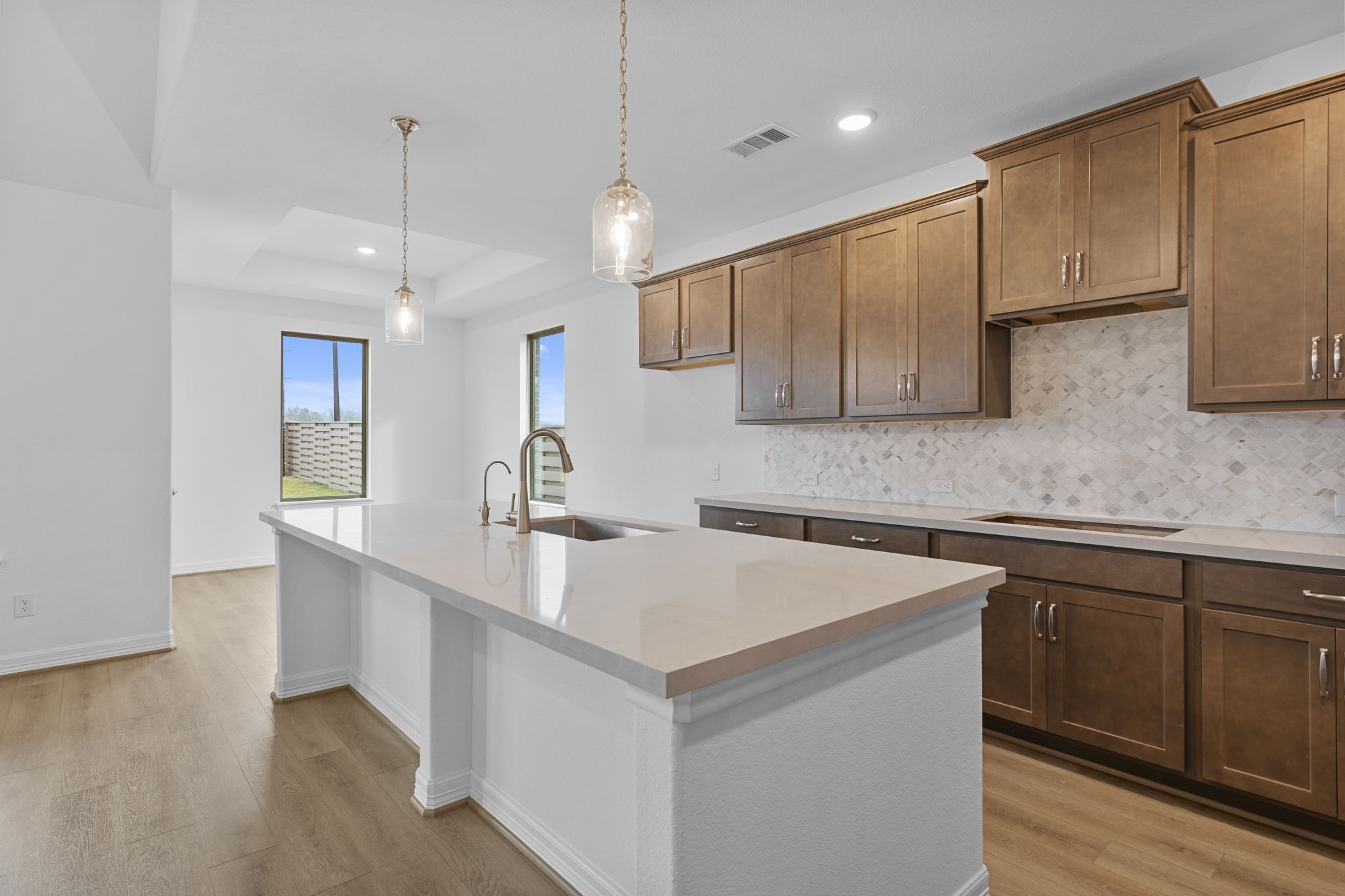 10639 Forward Street Richmond, TX 77469 - Photo 3 of 31 The kitchen anchors the home with deep finishes, statement textures, and an inviting layout made for gathering.