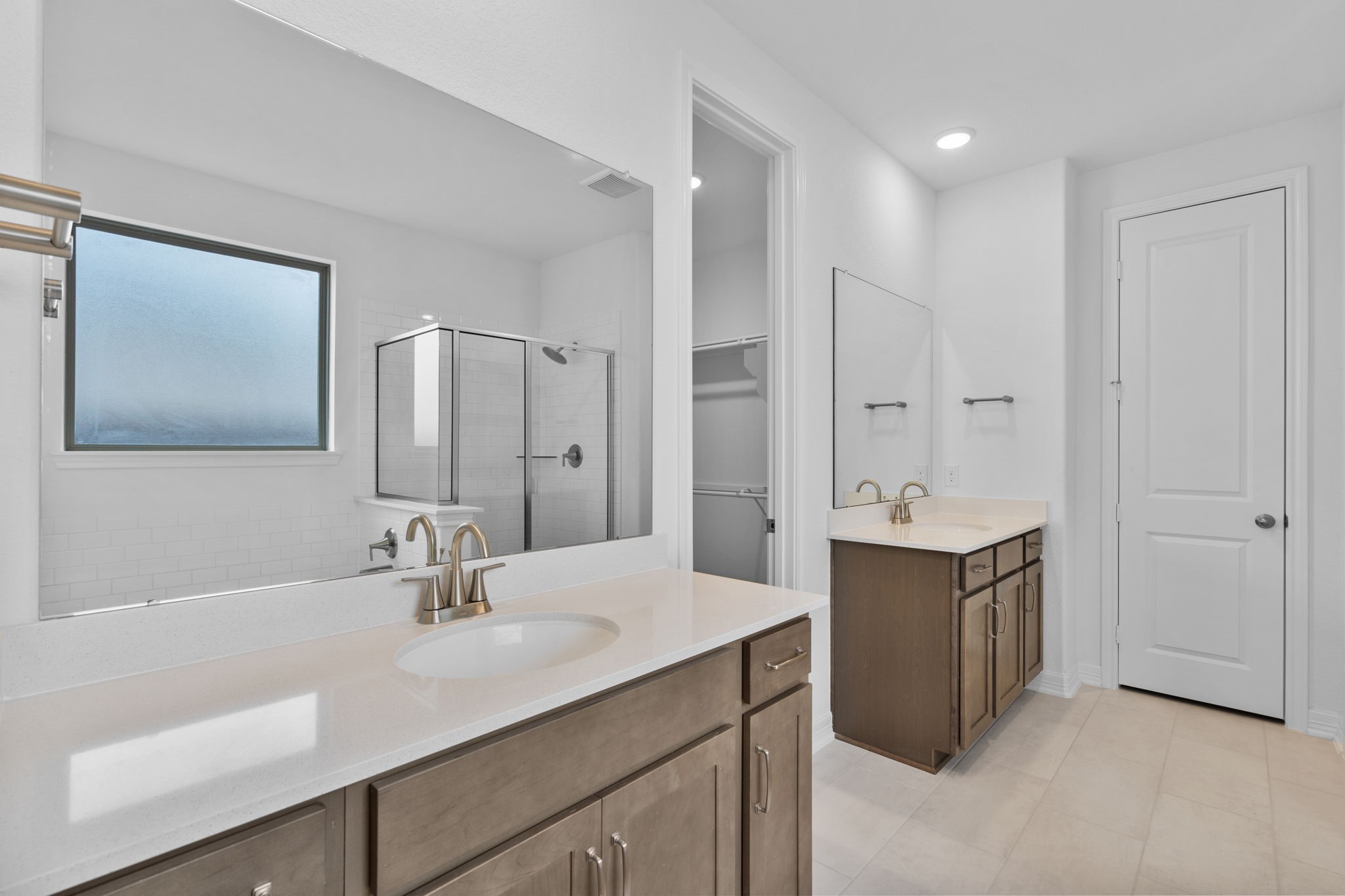 10639 Forward Street Richmond, TX 77469 - Photo 8 of 31 The primary bathroom features double vanities, rich stained cabinets, bright countertops, and luxe nickel finishes..