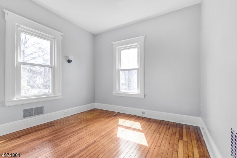 558 Summit Avenue, Unit 1 Westfield, NJ 07090 - Photo 3 of 13 an empty room with wooden floor and windows