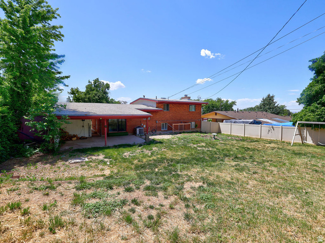 1272 Cook Street Ogden, UT 84404 - Photo 39 of 46 Spacious backyard featuring a covered patio, mature perimeter foliage, and a brick exterior