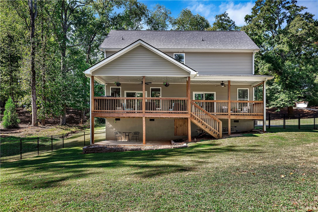 3004 Cobbs Way Anderson, SC 29621 - Photo 32 of 46 An elevated wooden deck overlooks a grassy backyard enclosed by metal fencing.
