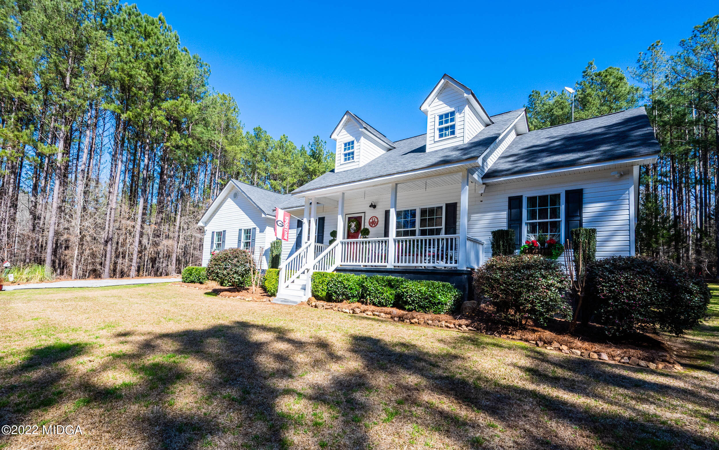 a front view of a house with a yard and potted plants