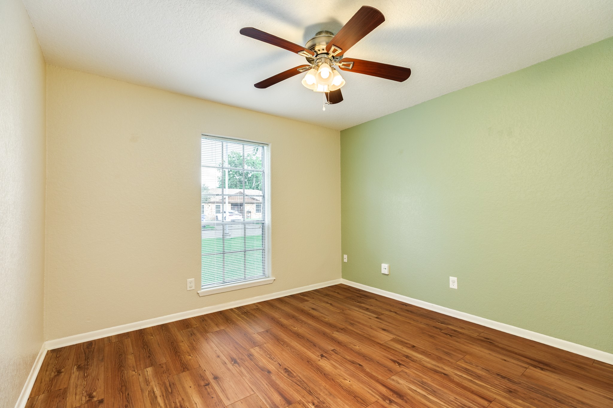 128 Houston Street Angleton, TX 77515 - Photo 22 of 25 an empty room with wooden floor and windows