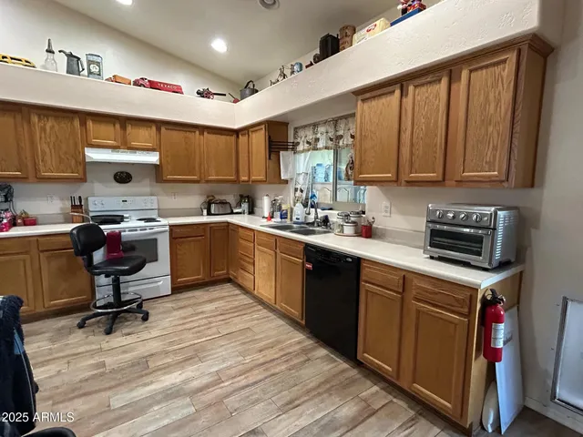 a kitchen with a sink a stove cabinets and wooden floor