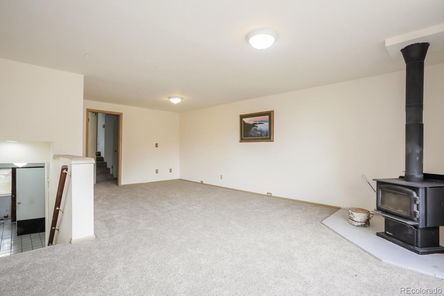 32038 Sylvan Road Golden, CO 80403 - Photo 9 of 28 a view of an empty room with a fireplace