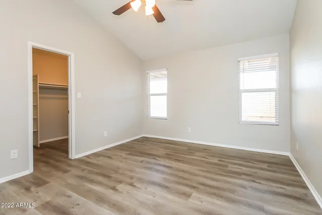 an empty room with windows and fan