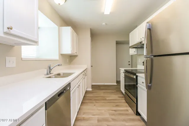 a kitchen with a sink a refrigerator and a stove