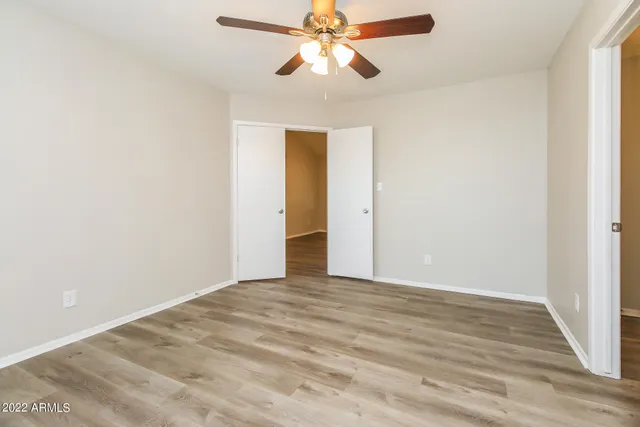 a view of an empty room and chandelier fan