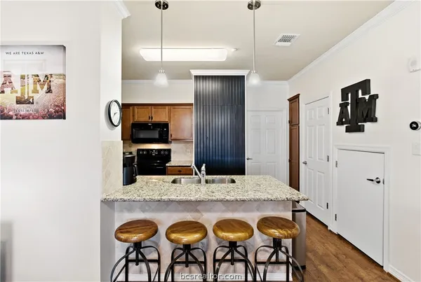 a kitchen with stainless steel appliances kitchen island granite countertop a refrigerator a stove and oven