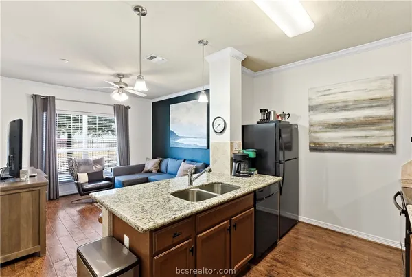a kitchen with granite countertop a sink a counter space appliances and cabinets