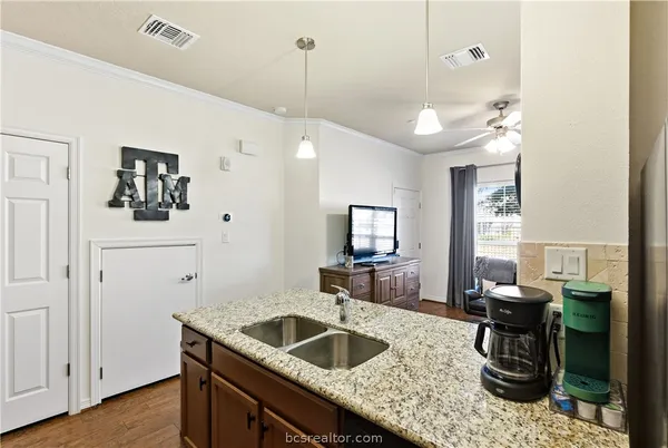 a kitchen with granite countertop stainless steel appliances a sink and a refrigerator