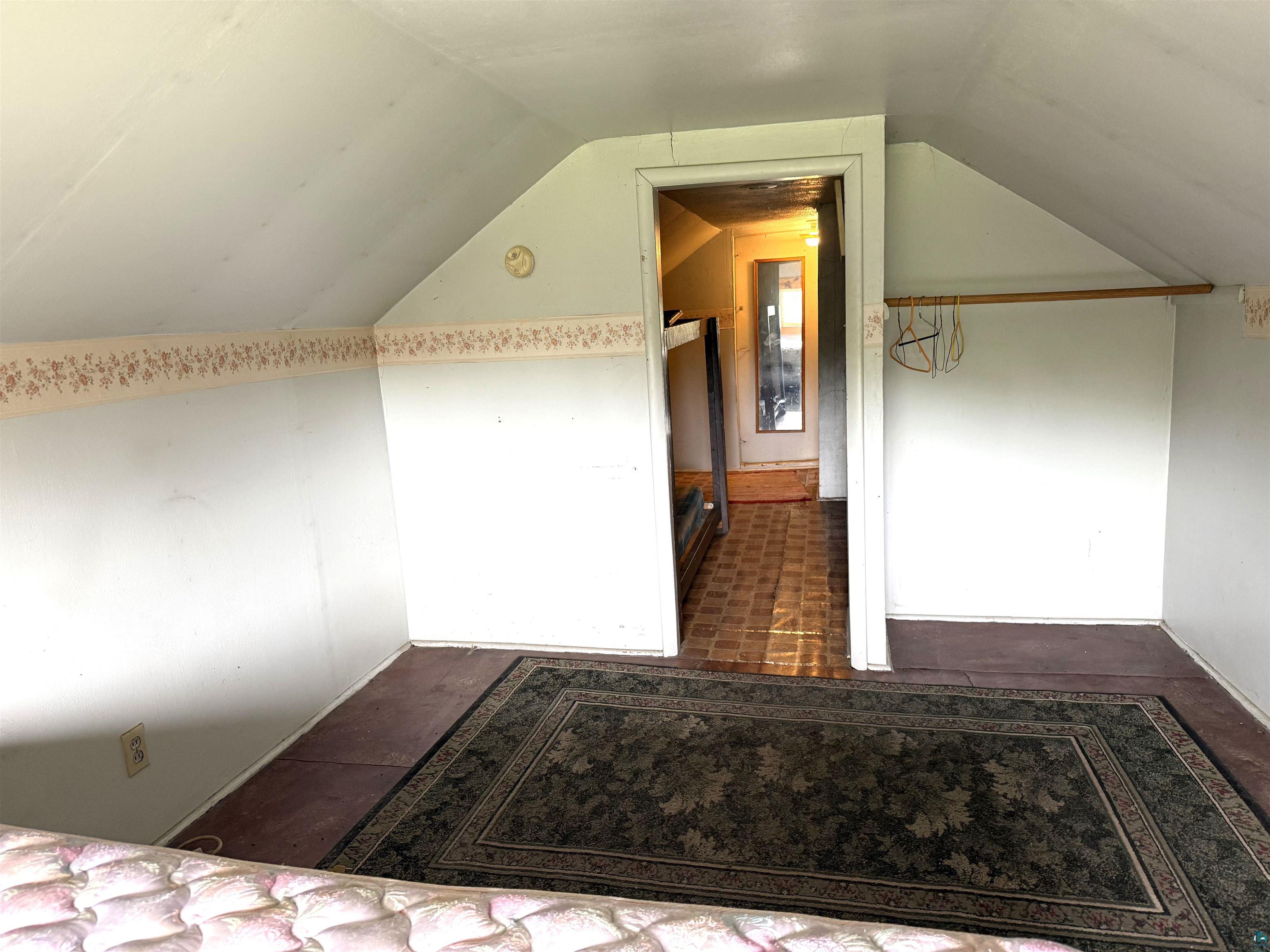 3541 Bent Trout Lake Road Barnum, MN 55707 - Photo 25 of 41 Attic space featuring sloped ceilings, a doorway, and a clothing rod