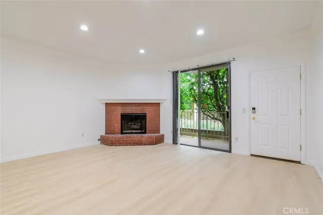 a view of an empty room with a fireplace and a window
