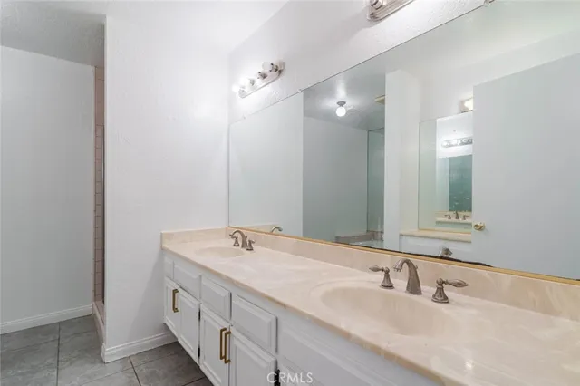 a bathroom with a double vanity sink and a mirror