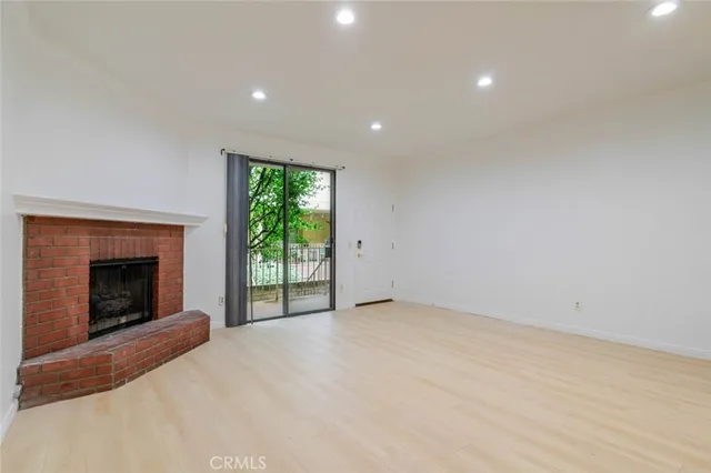 a view of empty room with a fireplace and window
