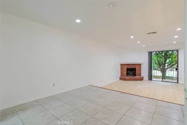 a view of an empty room with a fireplace and a window