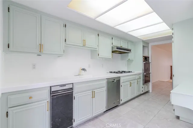 a kitchen with stainless steel appliances granite countertop a sink and a stove