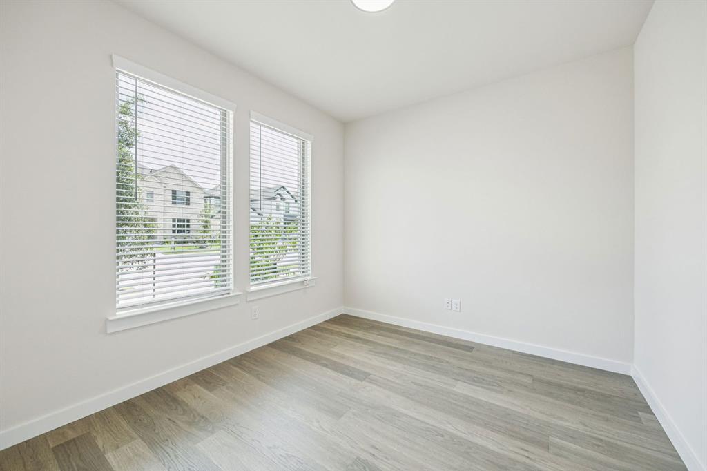 689 Moonlight Place Lavon, TX 75166 - Photo 19 of 29 a view of an empty room with wooden floor and a window