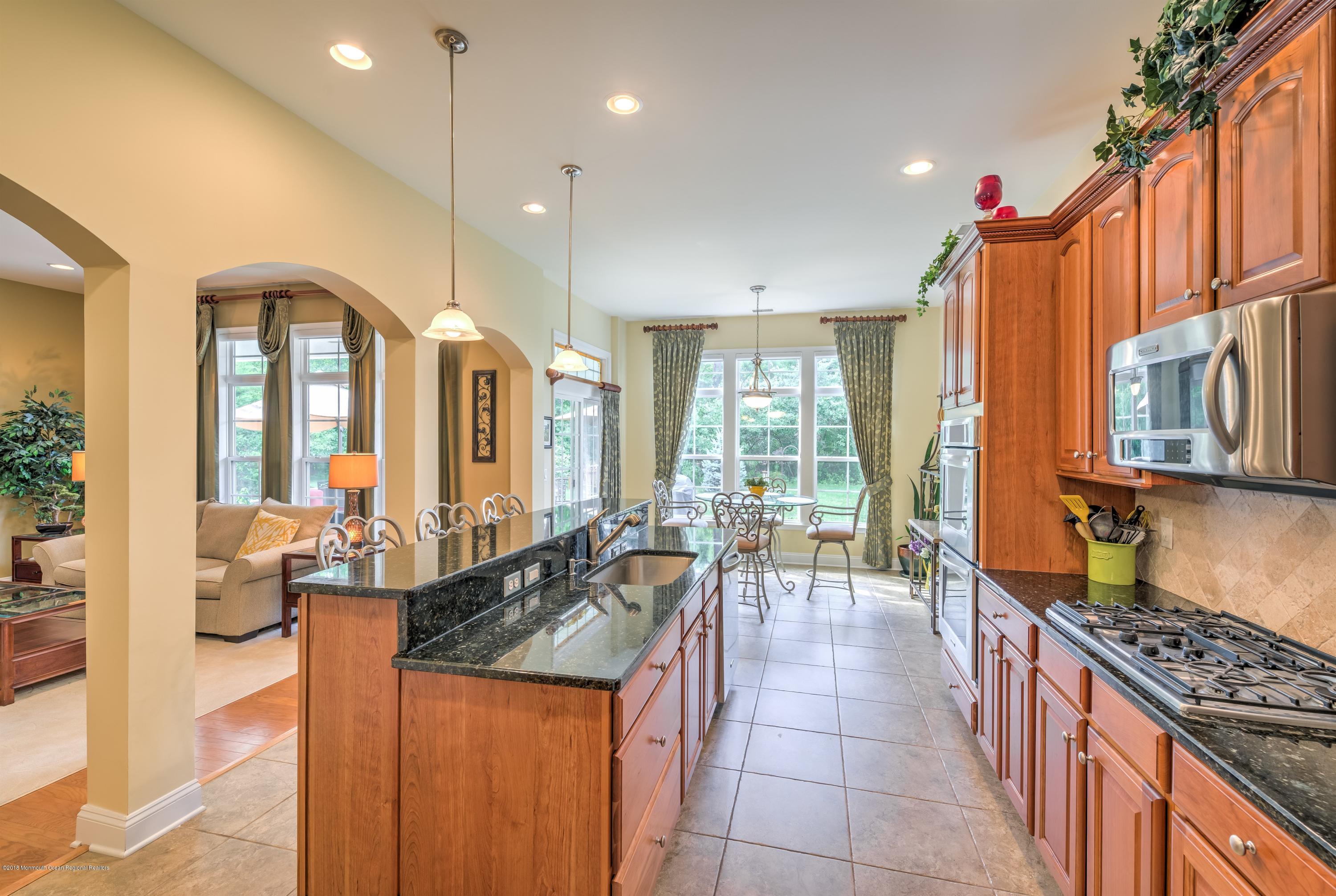 16 East Raphael Lane Farmingdale, NJ 07727 - Photo 14 of 50 a large kitchen with kitchen island granite countertop a large counter top space and stainless steel appliances