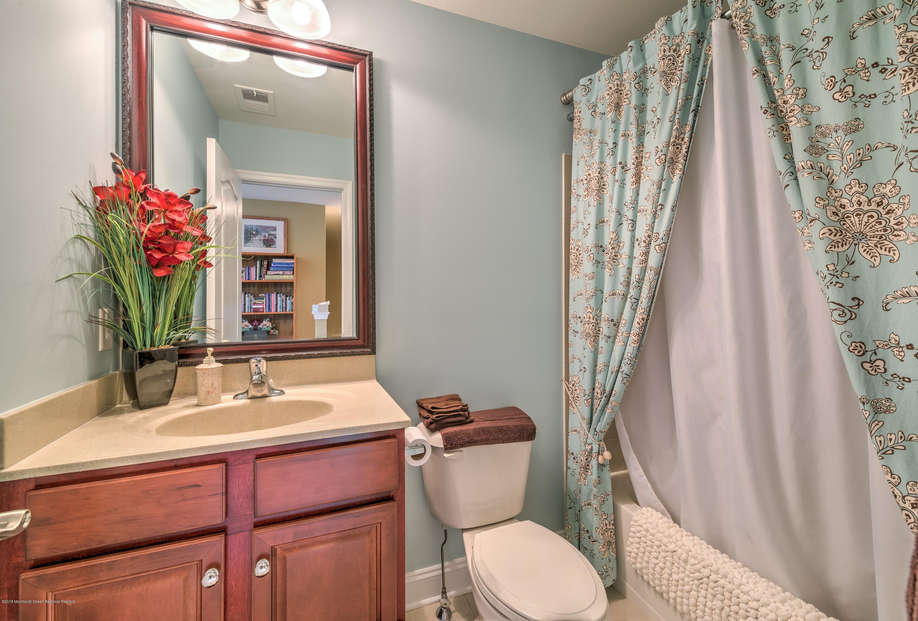 16 East Raphael Lane Farmingdale, NJ 07727 - Photo 25 of 50 a bathroom with a sink a toilet and a mirror