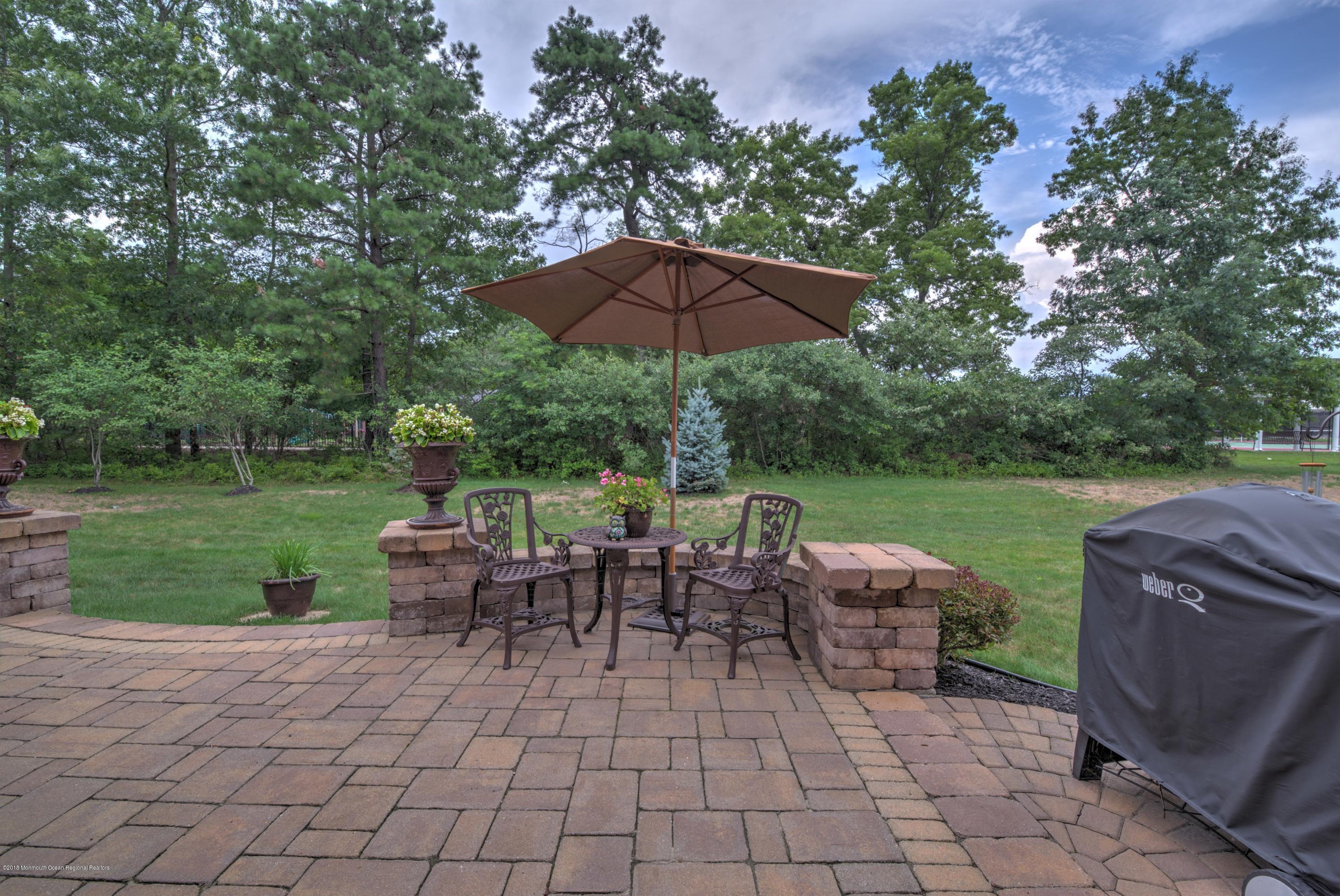 16 East Raphael Lane Farmingdale, NJ 07727 - Photo 28 of 50 a view of a patio with table and chairs under an umbrella