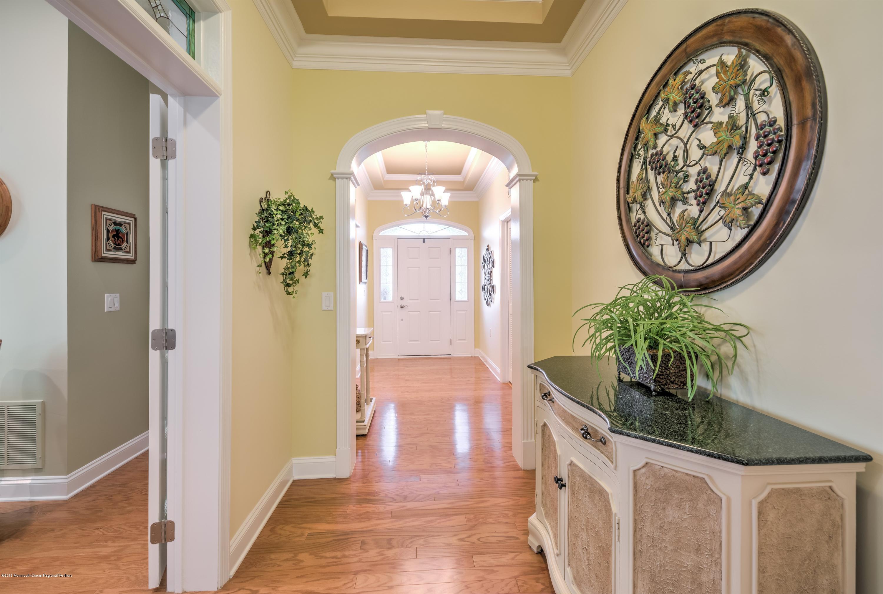 16 East Raphael Lane Farmingdale, NJ 07727 - Photo 7 of 50 a hallway with painting on the wall and a mirror