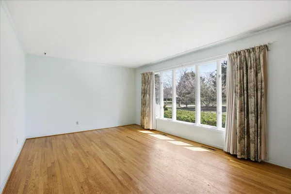 a view of a hallway with wooden floor and a chandelier