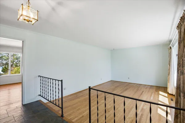 a view of a room with wooden floor and chandelier